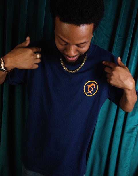 Man wearing Dungeon Forward - Once Upon - Midnight Premium Tee Shirt pointing at logo, showcasing storytelling and innovation.